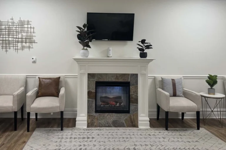 The Dental Family Cranford, NJ lobby of dental office with a fireplace and a television above it with chairs on either side.