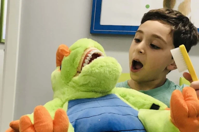 The Dental Family Junior in Cranford, NJ pediatric patient brushing a stuffed toy's teeth.