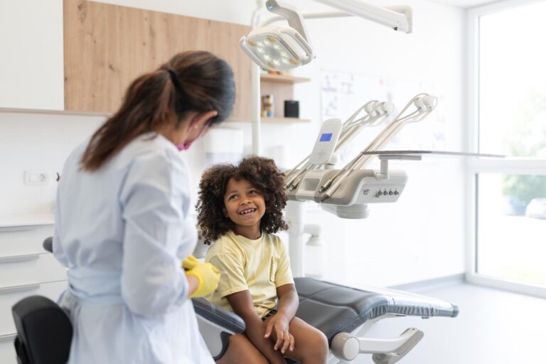 A friendly children's dentist talks about dental hygiene and tooth care in a relaxed, friendly manner with the child in the dental chair.